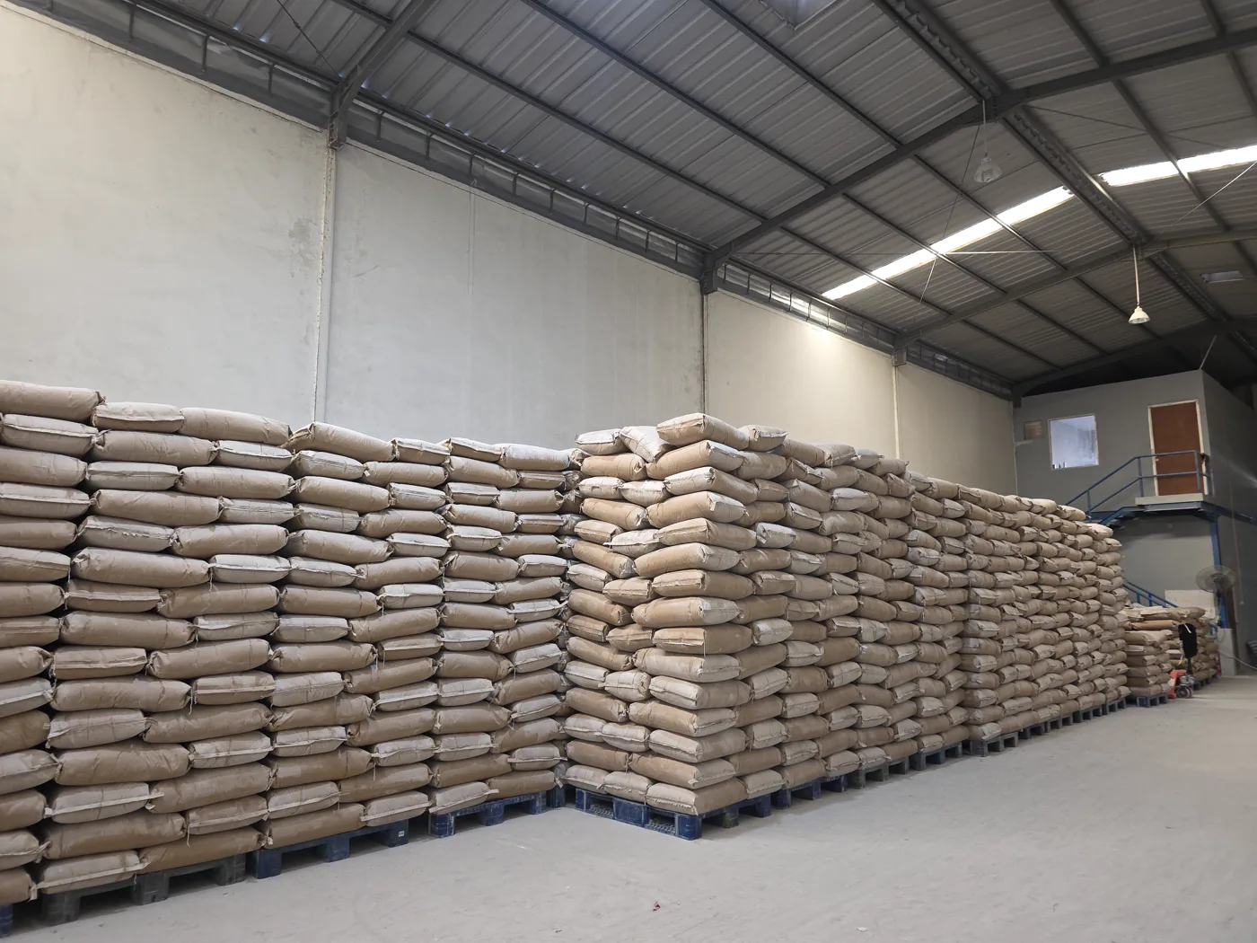 Deretan karung bahan industri di atas palet dalam gudang